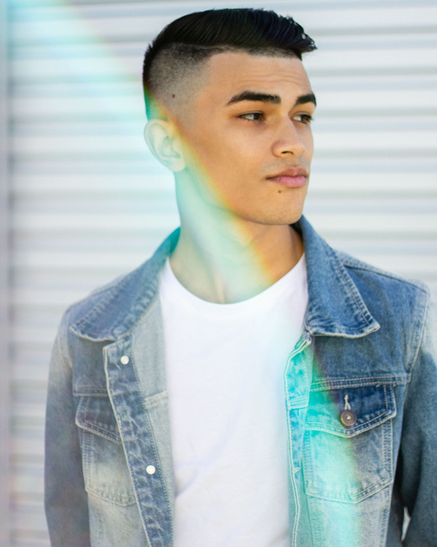 A male model with rainbow lens flare and denim jacket